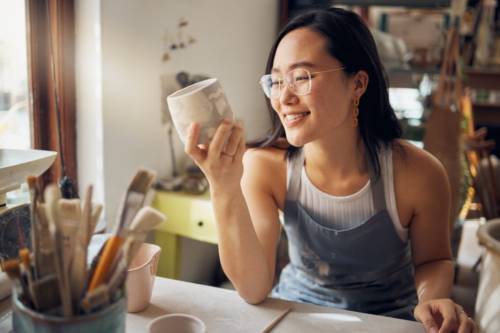 Artist, Asian and woman as small business entrepreneur happy about design and product at a workshop