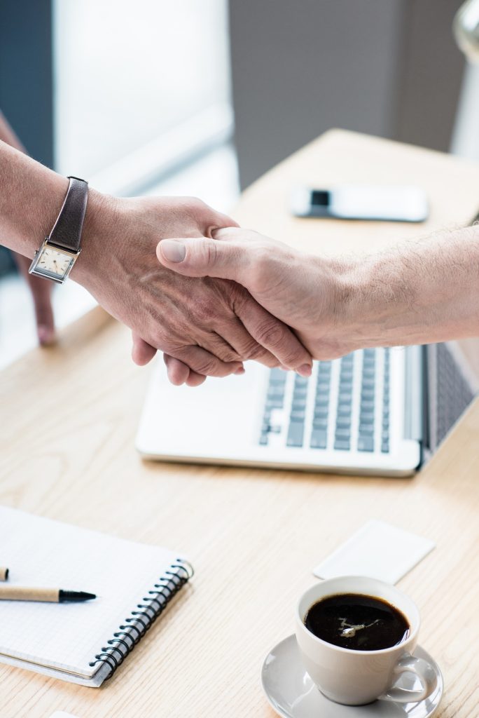 Business partners shaking hands at office